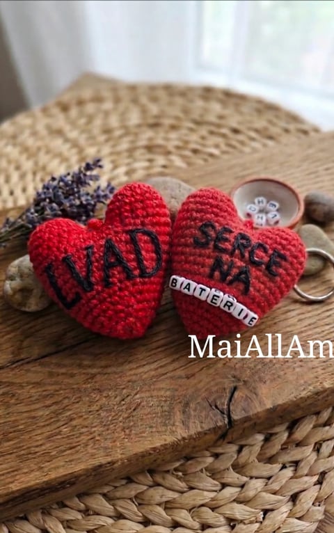 Handmade crocheted red heart keychains with text on natural wood tray with lavender and dried flowers